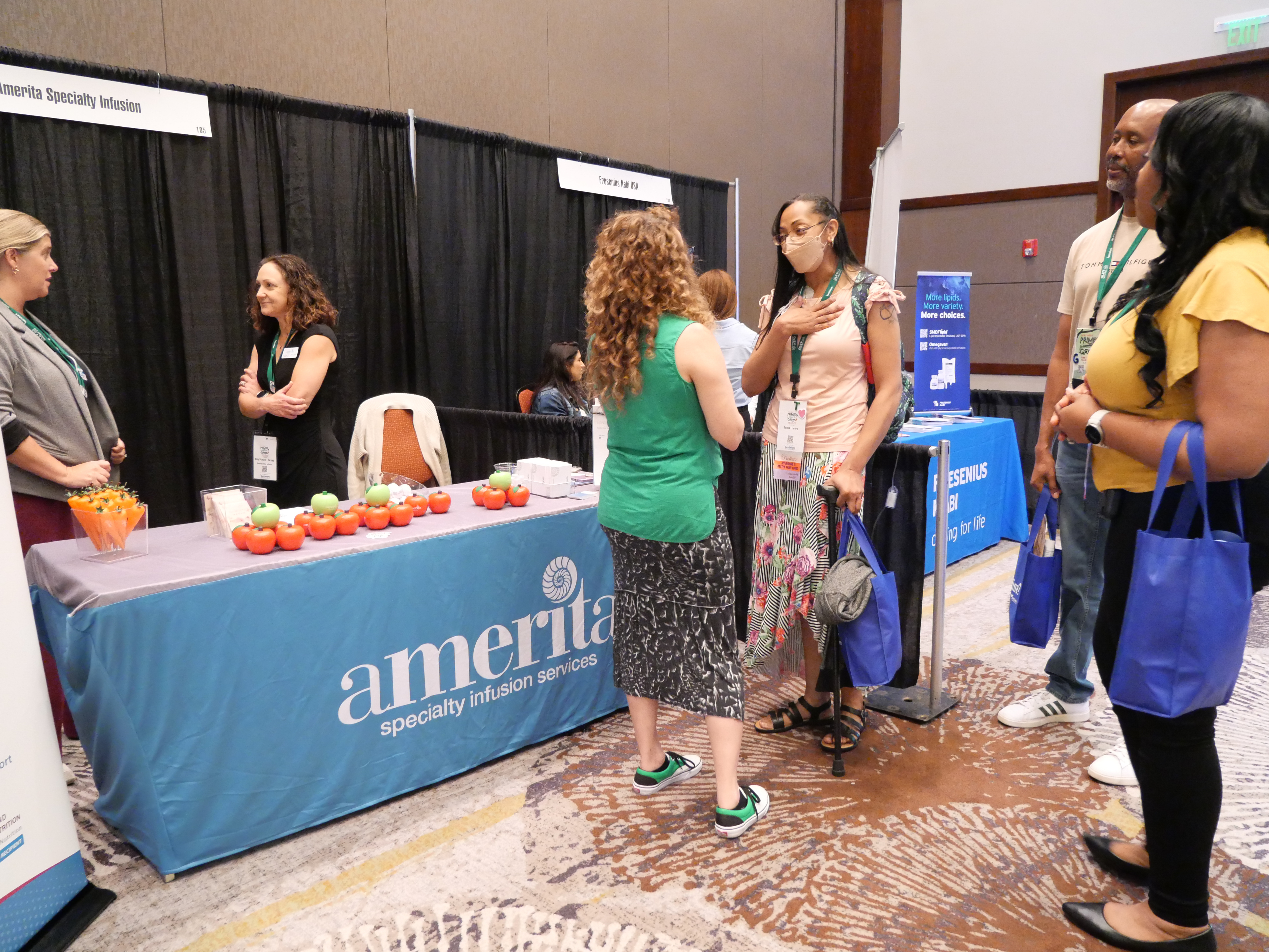 Attendees talking with exhibitors at the Experience Expo