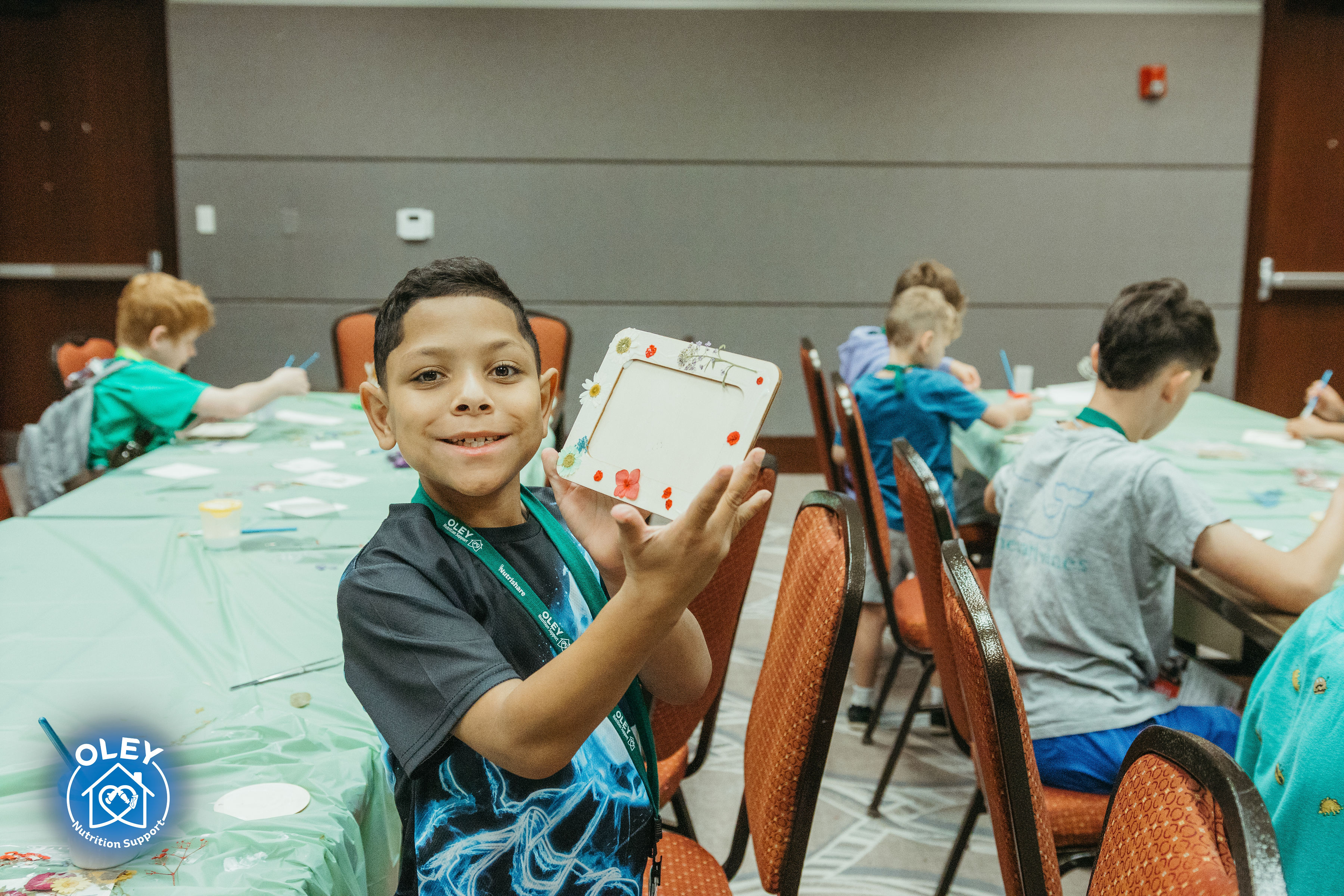 Child holding up a craft project during Kidz Klub