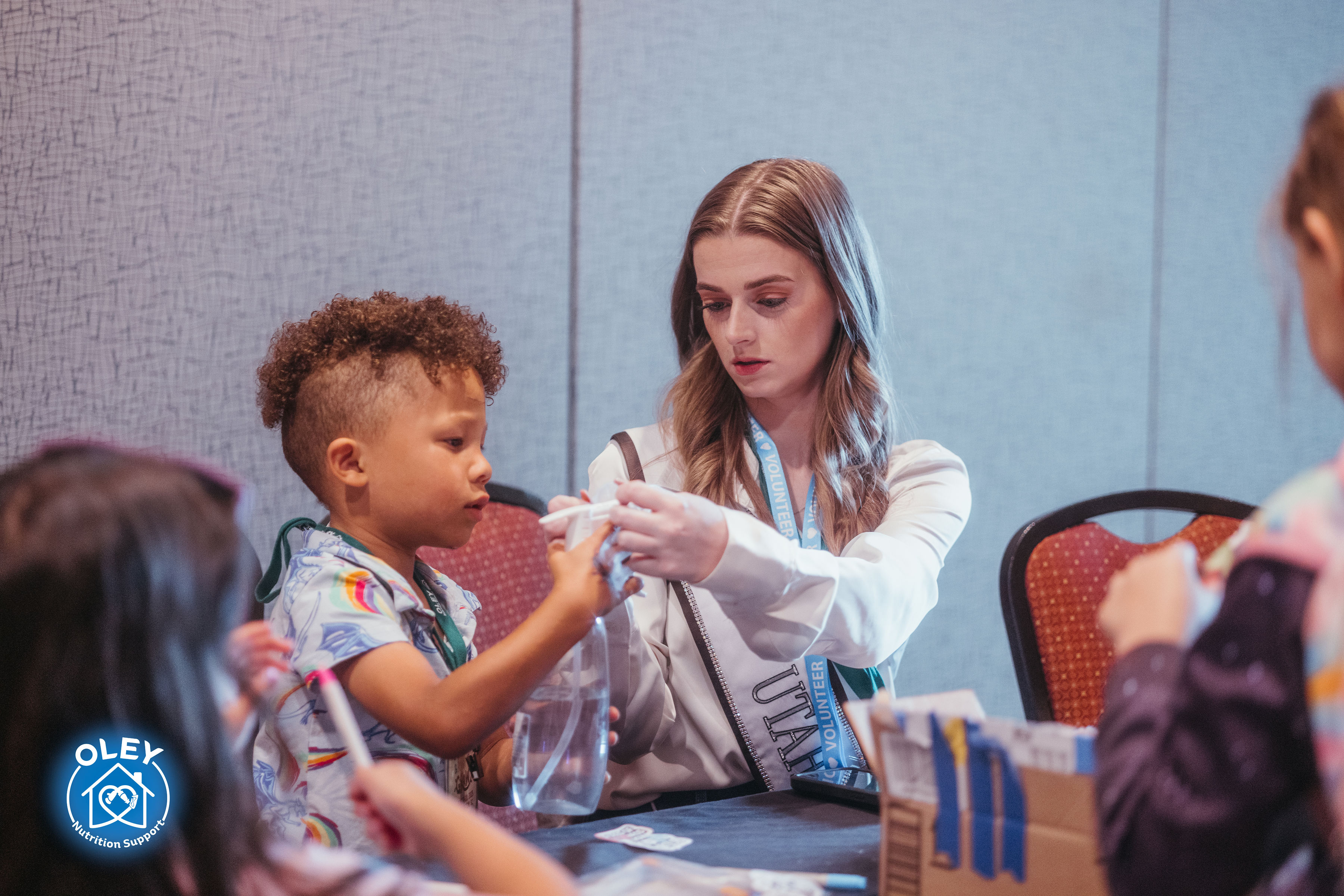 Volunteer assisting a child with an activity at a table